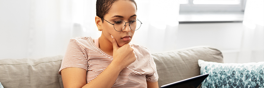 Person mit Brille schaut auf ein Tablet