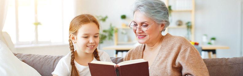 Ein Kind und ein Erwachsene lesen ein Buch